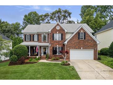 Charming two-story brick home with a manicured lawn and attached two-car garage at 11917 Ulsten Ln, Huntersville, NC 28078