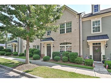 Charming brick townhome with a well-manicured lawn and lush landscaping at 1329 Jacemans Way, Cornelius, NC 28031
