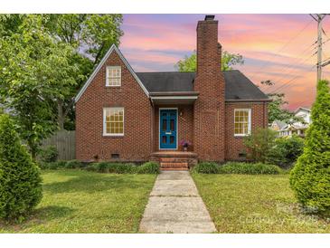Charming brick home with a striking blue front door and a well-manicured lawn at 1400 Matheson Ave, Charlotte, NC 28205