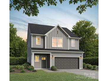 Charming two-story home boasts manicured lawn and two-car garage at 2031 Sadler Woods Ln, Charlotte, NC 28214