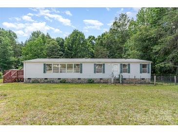Traditional single-story home with white siding, complemented by a well-maintained green lawn and surrounding trees at 3585 Woodstream Dr, Maiden, NC 28650