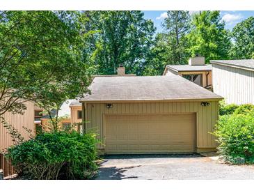 Attached garage with a tan door providing secure parking and additional storage space at 4025 Ivystone Ct, Charlotte, NC 28277