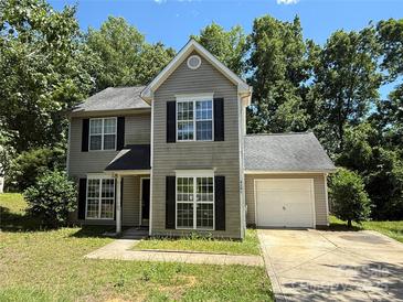 Charming two-story home featuring a one-car garage and manicured lawn surrounded by mature trees at 4240 Ladys Slipper Ln, Matthews, NC 28105