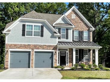 Charming two-story home with a stone and shingle facade, dark shutters, and a welcoming front porch at 5005 Blue Serenity Ct, Denver, NC 28037