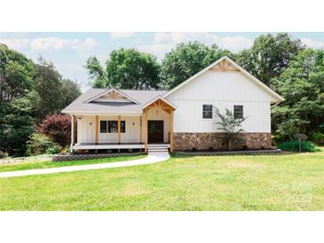 Inviting exterior showcasing a charming home with a covered porch and beautifully landscaped lawn at 8340 Brief Rd, Mint Hill, NC 28227