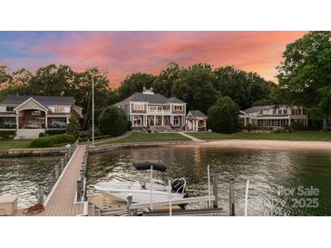 Stunning waterfront home with private dock, sandy beach, and mature trees under a colorful sky at 123 Sailview Rd, Mooresville, NC 28117