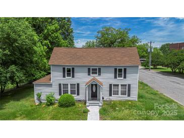 Charming two-story home featuring black shutters, light gray siding and well maintained landscaping at 315 E Washington Ave, Bessemer City, NC 28016