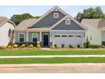 Charming single-Gathering home featuring a welcoming front porch and well-manicured lawn and two-car garage at 1029 Mapletree Ln, Indian Trail, NC 28079