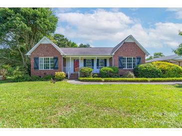 Charming brick home with a well-manicured lawn and inviting front porch and a red front door at 500 Belleview Rd, Rock Hill, SC 29730