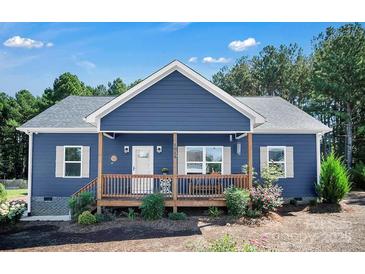 Charming blue home features a welcoming front porch, white trim, manicured landscaping, and a neatly kept yard at 5016 Old Pine Ln, Cherryville, NC 28021