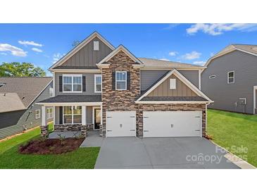 Beautiful two-story home with stone accents, a two-car garage, and manicured landscaping at 7184 Sylvan Retreat Dr, Denver, NC 28037