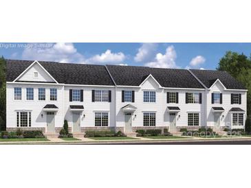Charming new construction townhouse community with sidewalk-lined street and manicured landscaping at 7332 Childress Dr, Concord, NC 28025