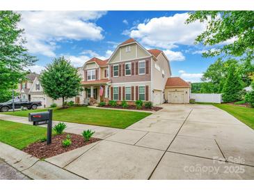 Inviting two-story home with a well-manicured lawn, charming shutters, and an attached two-car garage at 85017 Newloch Ct, Lancaster, SC 29720