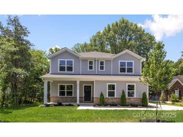 Beautiful two-story home with manicured lawn, stone accents, and a welcoming front porch at 2313 Stallings Rd, Harrisburg, NC 28075