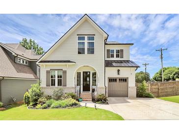 Beautiful two-story home featuring a landscaped yard, brick accents, and a welcoming arched entryway and modern curb appeal at 2600 Palm Ave, Charlotte, NC 28205