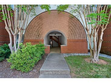 Inviting entryway featuring a unique brick archway and well-maintained landscaping at 2625 E 5Th St # F, Charlotte, NC 28204