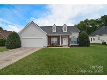Charming single-Gathering home featuring a manicured lawn, attached garage, and inviting front porch with dormer windows at 2836 Rosemeade Dr, Monroe, NC 28110