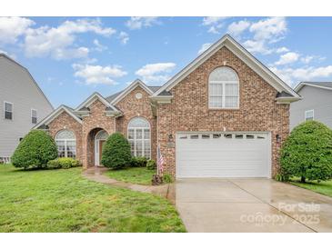 Charming brick home with well-maintained lawn, arched windows, and a two-car garage at 5052 Ashley Pl, Bessemer City, NC 28016