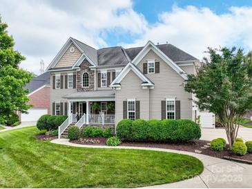 Stunning two-story home featuring stone accents, a covered front porch, and professionally landscaped yard at 538 Fairwoods Dr, Huntersville, NC 28078