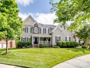Charming two-story home with a welcoming front porch and beautifully landscaped front yard at 538 Fairwoods Dr, Huntersville, NC 28078