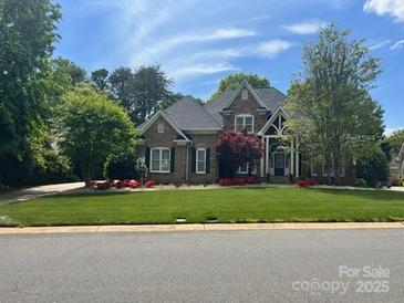 Charming two-story home with brick and stone, manicured lawn and colorful landscaping in a desirable neighborhood at 7018 Dowington Dr, Charlotte, NC 28277