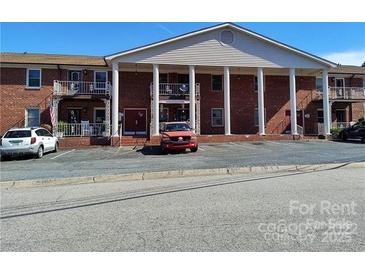 Apartment building featuring a stately facade with brick and prominent columns, complemented by a spacious parking area at 2106 S Main St, Kannapolis, NC 28081