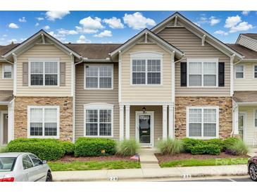 Charming townhome exterior with stone accents, well-maintained landscaping, and a welcoming front porch at 228 Dawn Mist Ln, Fort Mill, SC 29708