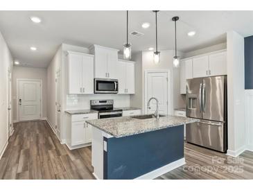Modern kitchen with granite countertops, stainless steel appliances, and a center island at 502 Tayberry Ln, Fort Mill, SC 29715