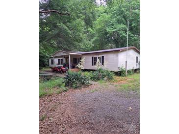 Charming single-story home with mature trees and landscaping around the perimeter at 5023 Dogwood Ln, Stanley, NC 28164