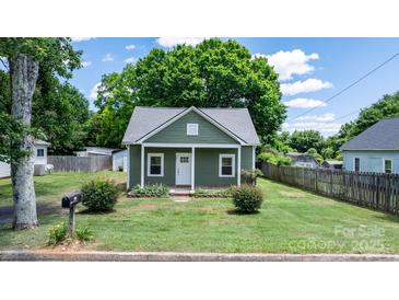 Charming green cottage with a well-maintained lawn and inviting front porch at 639 S Eastway Dr, Troutman, NC 28166