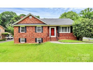 Charming brick home with a well-maintained lawn and a bright red front door at 6908 Lancer Dr, Charlotte, NC 28226