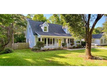 Charming home featuring light blue siding, a welcoming porch with a yellow door, and a well-maintained front yard at 8742 Rittenhouse Cir, Charlotte, NC 28270