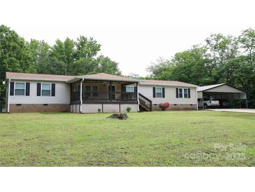 Charming ranch-style home with a covered front porch and carport provides ample parking and curb appeal at 1184 Sherwood Rd, Clover, SC 29710