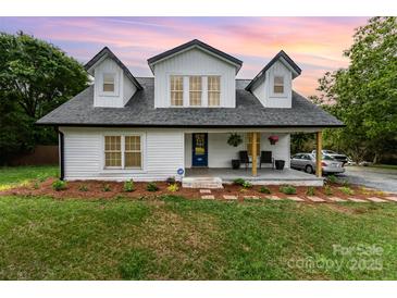 Charming two-story farmhouse with a welcoming front porch and manicured lawn at 12504 Culp Rd, Gold Hill, NC 28071
