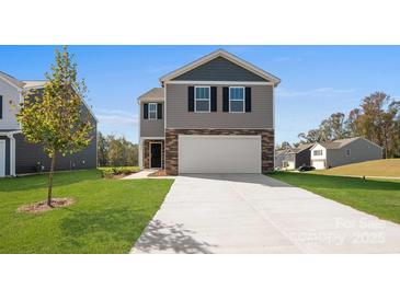 Two story home featuring gray siding and stone accents, a two-car garage, and a well-manicured lawn at 3064 Ora Smith Rd, Lincolnton, NC 28092