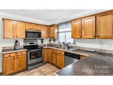 Well-lit kitchen with wood cabinetry, stainless steel appliances, and a neutral countertop at 4285 Palmer Lloyd Rd, Lancaster, SC 29720