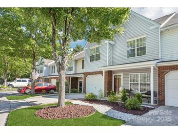 Charming townhouse featuring a brick facade, well-kept landscaping, and an inviting entryway with seating at 8108 Christmas Ct, Charlotte, NC 28216