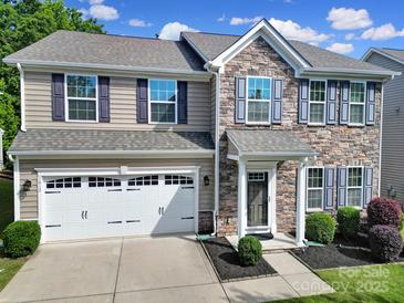 Charming two-story home featuring stone accents, a two-car garage, and beautifully landscaped front yard at 1012 Kings Bottom Dr, Fort Mill, SC 29715