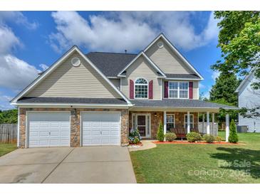 Charming two-story home featuring stone accents, a two-car garage, and a welcoming front porch at 166 Glenn Allen Rd, Mooresville, NC 28115