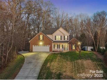 Charming two-story home with a brick facade, manicured lawn, and a welcoming front porch at 1730 Eden Glen Dr, Dallas, NC 28034