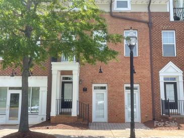 Charming brick townhome with inviting entrance and mature tree in the front at 2411 Bonterra Blvd, Indian Trail, NC 28079