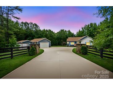 Charming home with long driveway, lush lawn, and stone accents near trees, offering curb appeal and privacy at 2949 Anderson Burgess Rd, Sharon, SC 29742