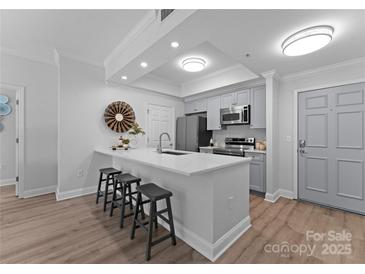 Bright kitchen features a quartz countertop island with barstool seating and stainless steel appliances at 300 W Fifth St # 509, Charlotte, NC 28202