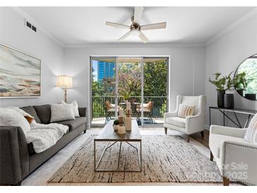 Bright living room with ceiling fan, access to a private balcony, and comfortable seating at 300 W Fifth St # 509, Charlotte, NC 28202