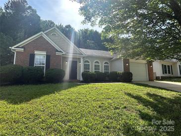 Charming single-story home featuring brick accents, a well-manicured lawn, and an attached two-car garage at 3124 Burkston Rd, Charlotte, NC 28269