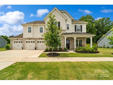 Charming two-story home with stone accents, a three-car garage, and a beautifully landscaped front yard at 433 Sinaloa St, Waxhaw, NC 28173