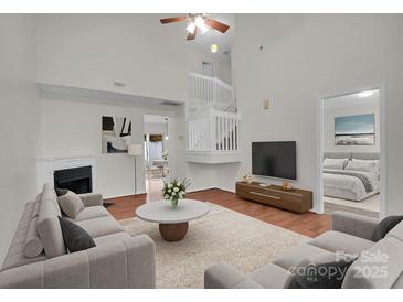 Bright living room with fireplace, high ceilings, and an open view to the staircase at 5237 Ficus Tree Ln, Charlotte, NC 28215