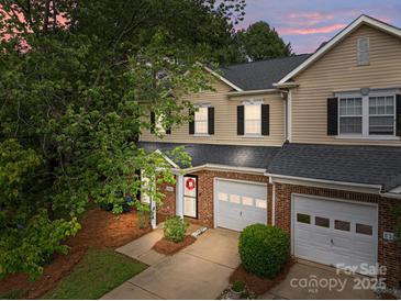 Charming townhome featuring a brick facade, attached garage, and well-manicured front yard at 5305 Waverly Lynn Ln # 4A, Charlotte, NC 28269