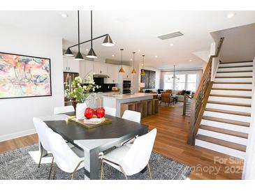 Bright dining room area with gray table, white chairs, and an open view to the kitchen and living room at 8044 Cedarsmith Ct, Charlotte, NC 28217
