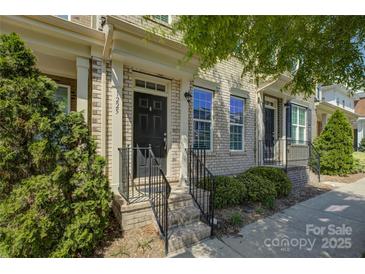 Charming brick townhouse with a black front door, trimmed bushes and well-manicured front yard at 1225 Assembly St, Belmont, NC 28012